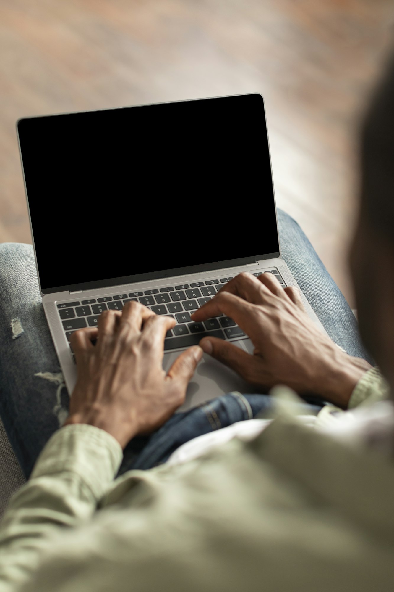 Mature black guy typing on computer keyboard with blank screen, recommends website in living room