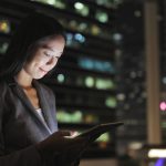 Businesswoman using digital tablet at night